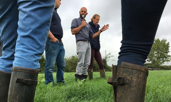 Man speaking to group on farm.